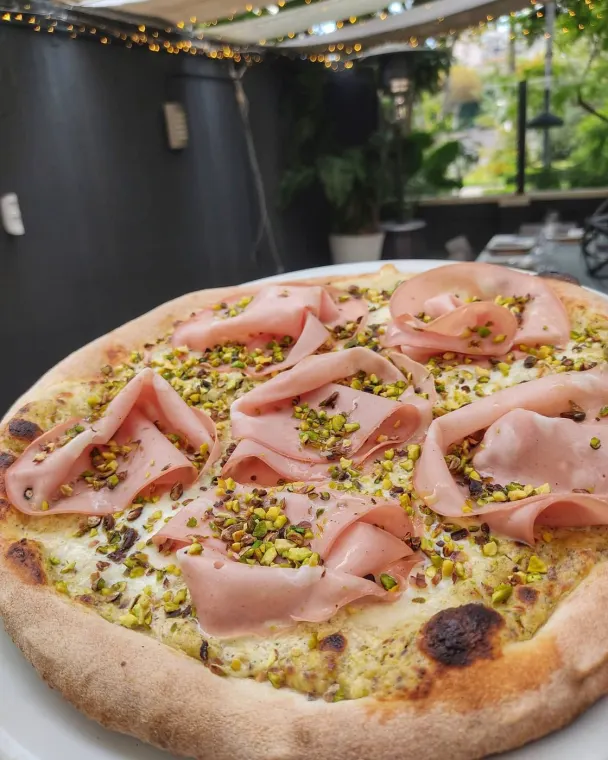 Pizza bianca con crema di pistacchio, mortadella a rosette e granella