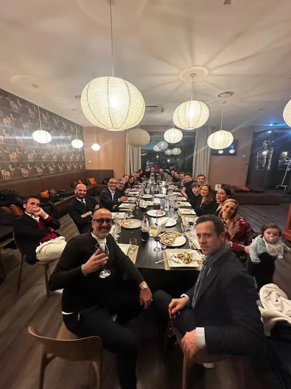 Una tavolata di ospiti nella sala interna durante una serata