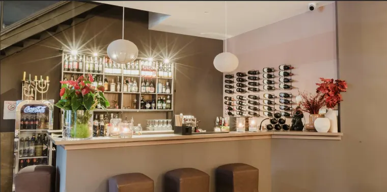 La parete dei vini alle spalle del banco, con le bottiglie in fila