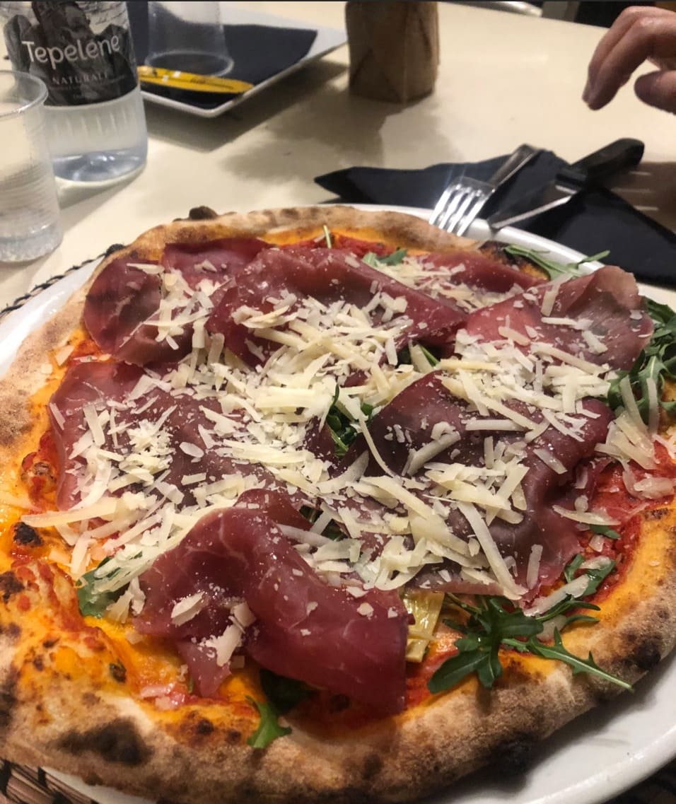 A close-up of the rim of a pizza just out of the oven